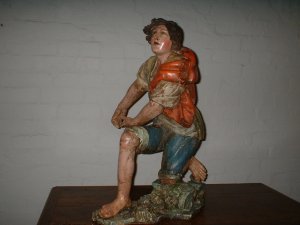  763  A RARE CARVED WOOD AND PAINTED KNEELING FISHERMAN