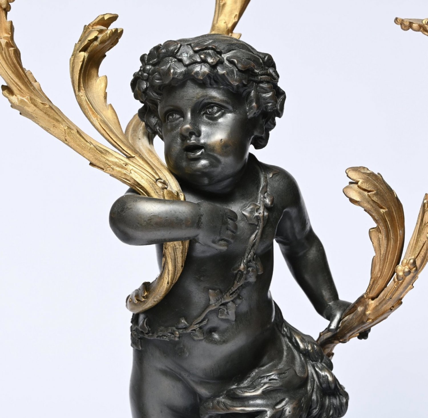An Exceptional Pair of French Louis XVI Style Patinated and Gilt Bronze Three-Light Candelabra, after Clodion. Circa 1830.