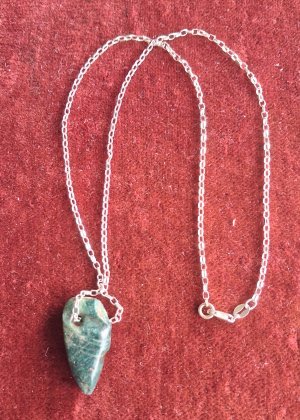 Necklace with greenstone bead depicting a bird’s head.